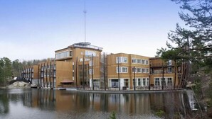 A multi-story hotel with a modern design, located near a body of water. - Dyreparken Safarihotell (Kristiansand)