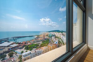 A coastal cityscape with a prominent bridge, historic buildings, and a view through a window. - Rei Gallery Phu Quoc - Ocean (Phu Quoc)