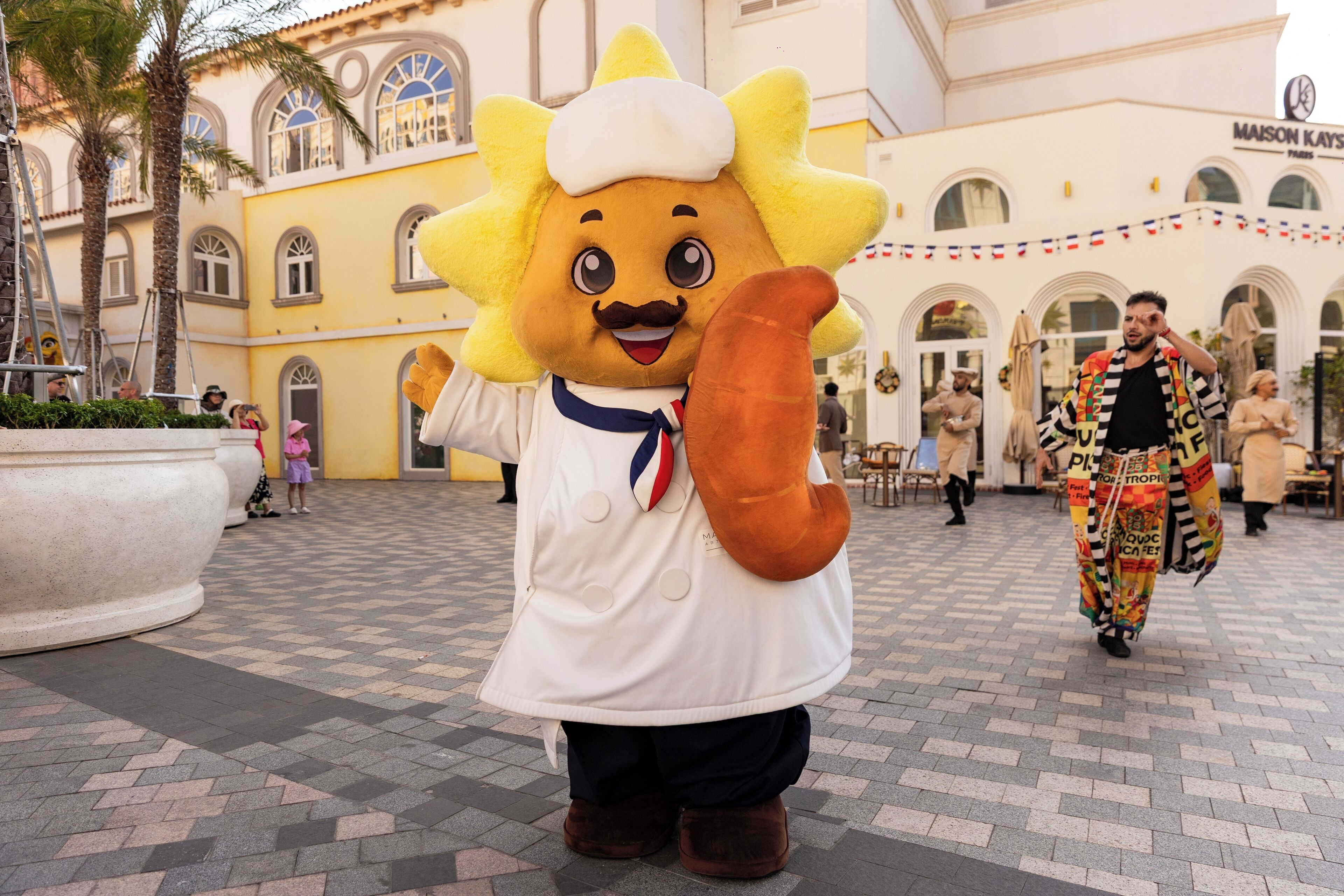 A mascot in a plaza with a building in the background.