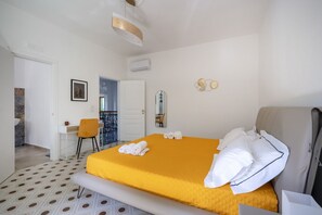A hotel room with a bed, a chair, a desk, a mirror, and a bathroom visible through an open door. - GuestHost - Large room ideal for two, featuring a private bathroom and located in a villa in Borgo Lucia, a complex with a large shared garden. Surrounded by greenery, the accommodation is located in Selva di Fasano, a quiet hillside hamlet in the munici (Selva di Fasano)