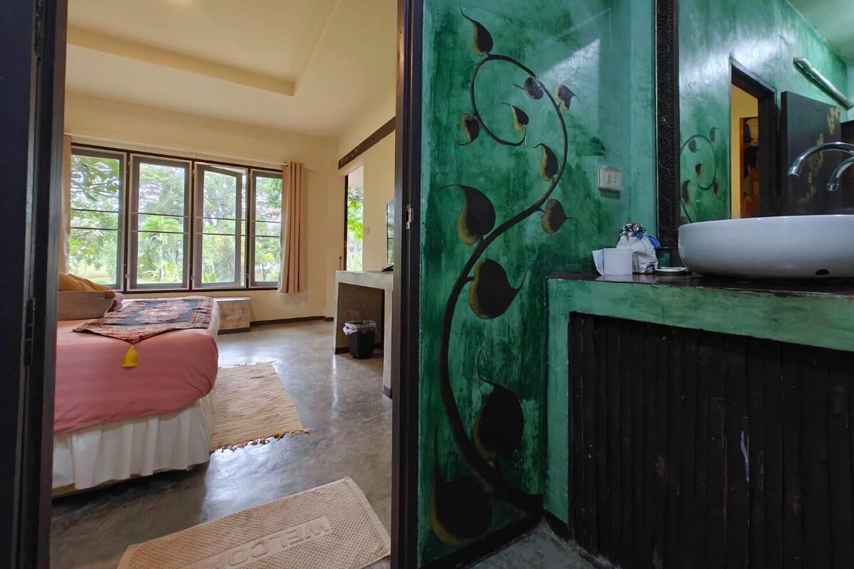 A bedroom with a bed, a bedside table, and a window.