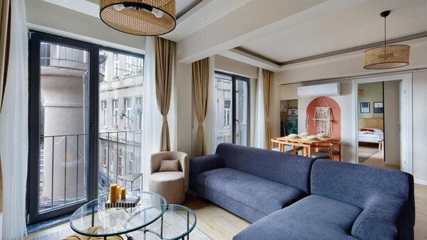 Un soggiorno moderno con un divano ampio, un tavolino in vetro e una zona pranzo con tavolo e sedie.