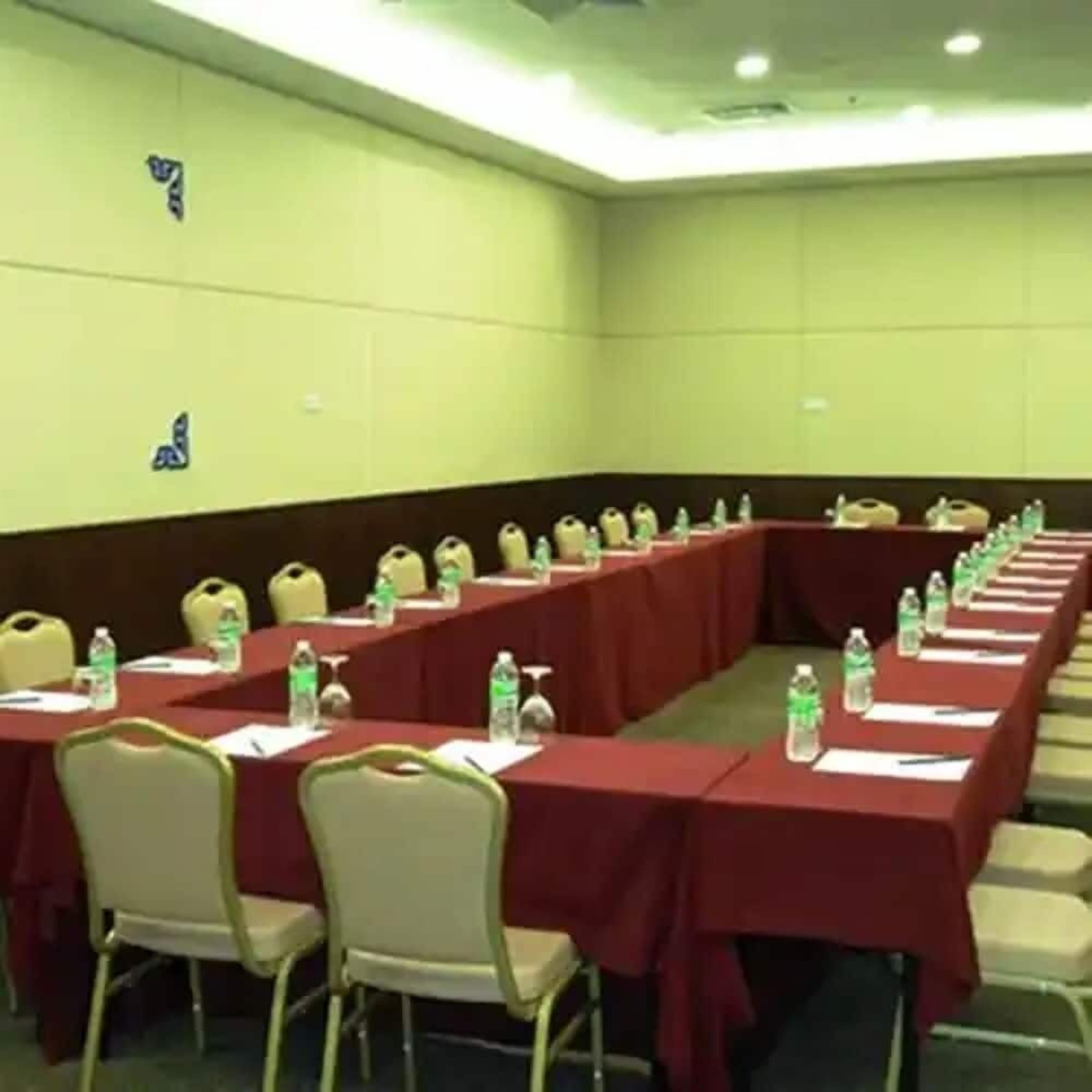 A conference room with a long table, chairs, and water bottles.