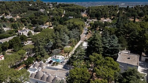 Zona residencial amb piscina, arbres i vistes al mar.