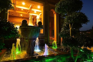 A nighttime view of a fountain with water jets and a building entrance. - Marugarh (Jodhpur)