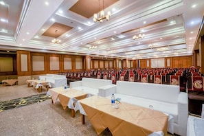 A conference room with rows of white sofas, tables with tablecloths, and a patterned carpet. - Marugarh (Jodhpur)