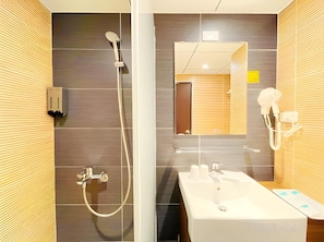 Ein modernes Badezimmer mit Dusche, Waschbecken und Spiegel.
