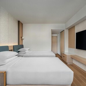 A modern hotel room with two beds, a flat-screen TV mounted on the wall, and a wooden cabinet. - Hotel Crown Palais Kobe (Kobe)
