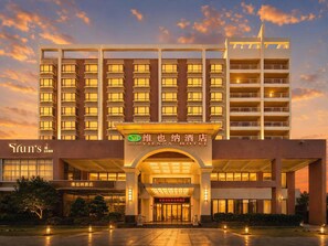 A hotel with a modern facade, multiple balconies, and a prominent entrance. - Vienna Hotel (Dongguan)
