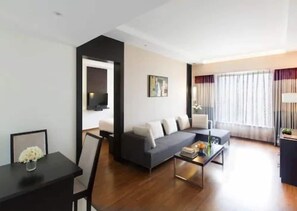 Un salon moderne avec un canapé, une table basse et un téléviseur fixé au mur.
