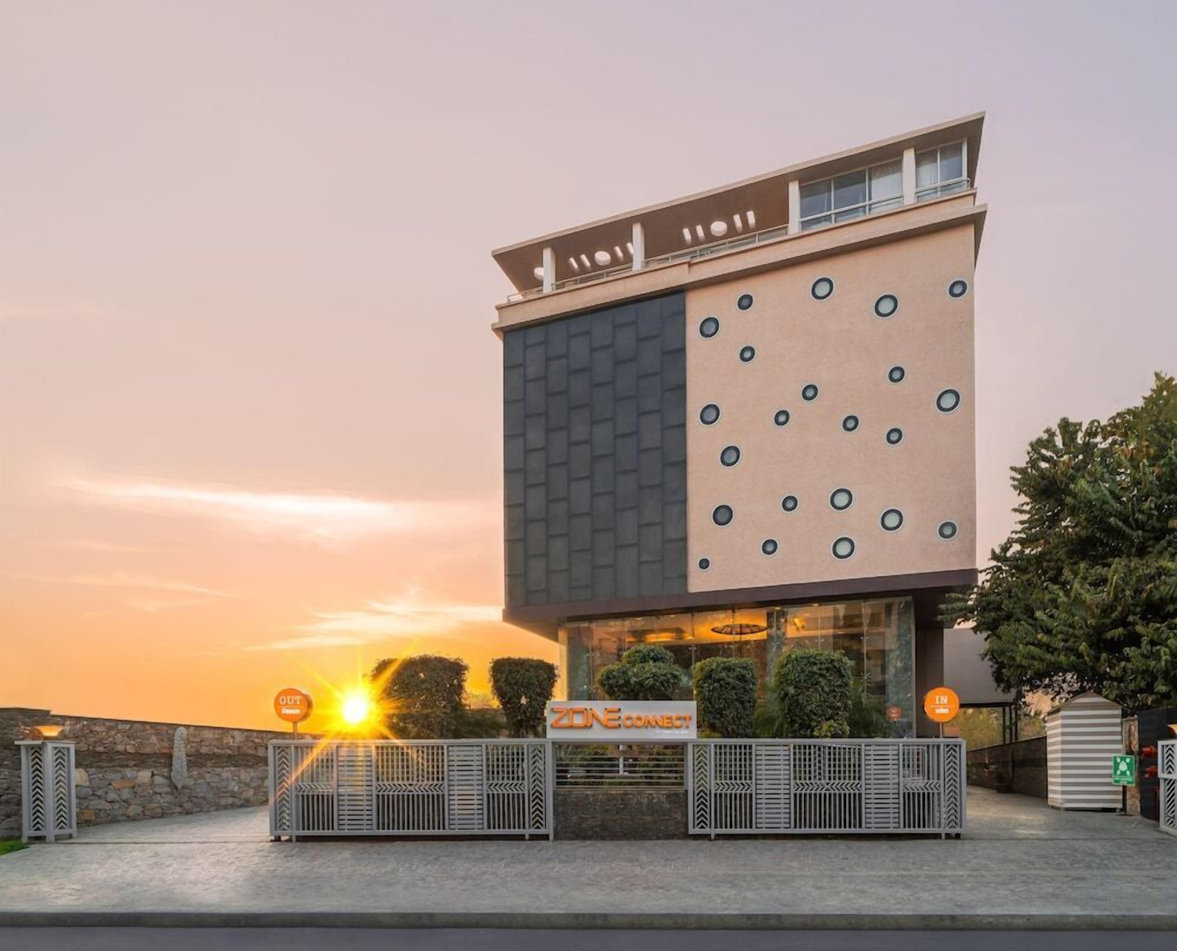 A modern building with a unique facade featuring circular patterns and a mix of brick and glass materials.