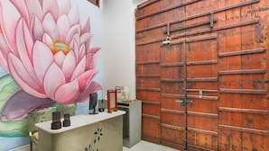 A reception desk with a floral mural, a large wooden door, and a modern interior design. - Fateh Garh (Udaipur)