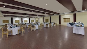 Une grande salle dotée de nombreuses tables rondes et de chaises, disposées pour un événement officiel.