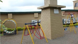 Un parque infantil con columpios y una hamaca.