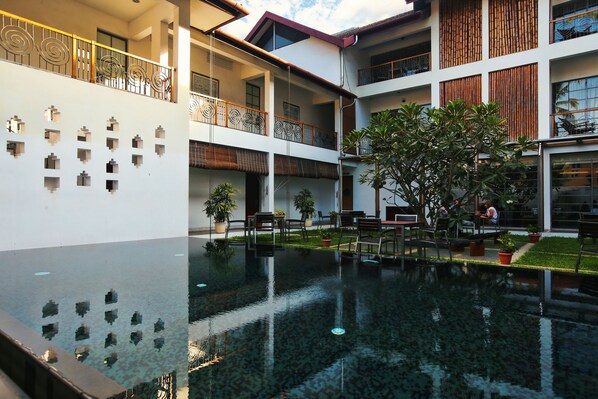 A multi-level building with a central courtyard, outdoor seating, and a pool. - Eighth Bastion Fort Kochi - A CGH Earth Experience (Kochi)