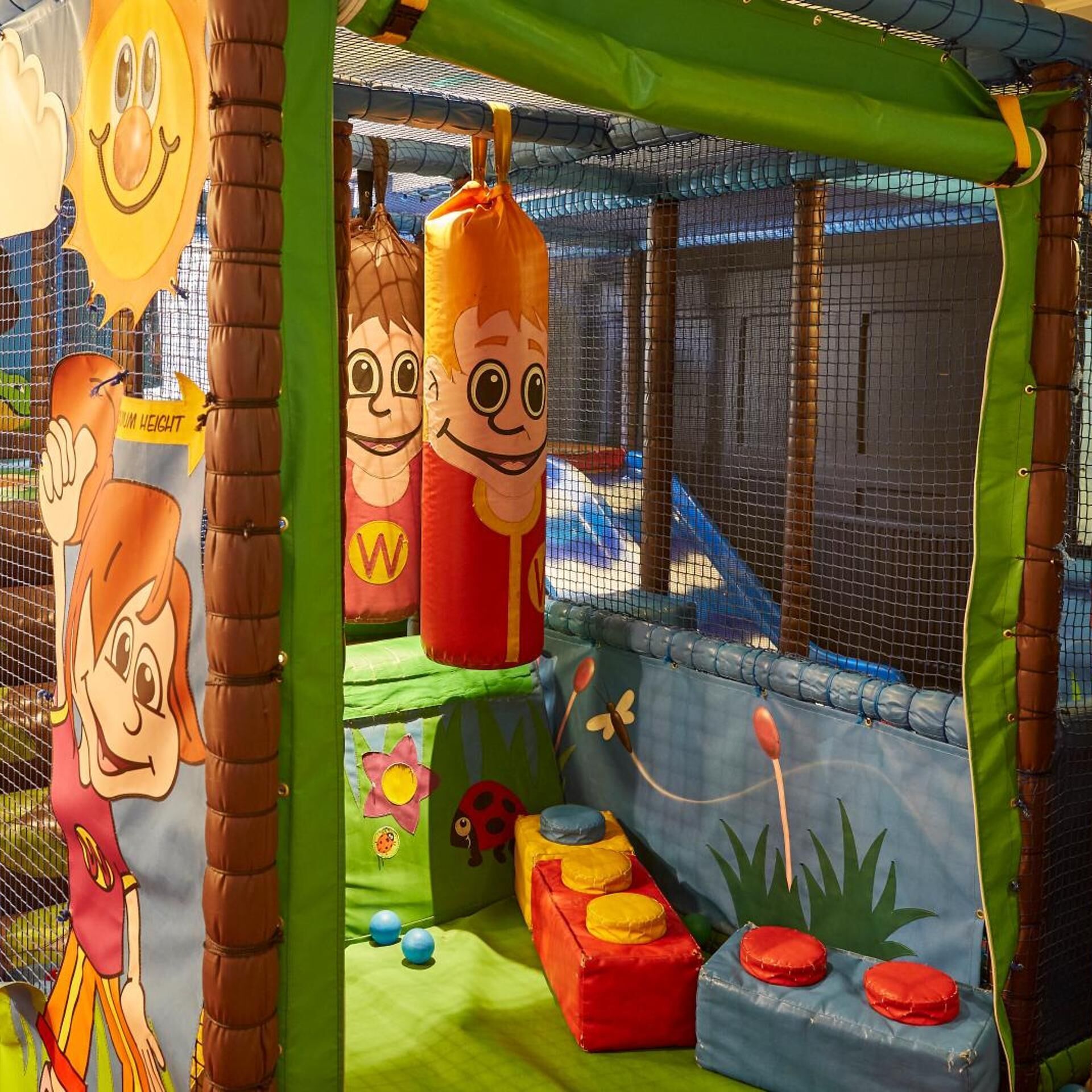 A children's play area with cartoon characters, a punching bag, and soft play structures.