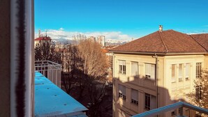 A building with a tiled roof and multiple windows, viewed from a balcony. - Eleganza Metropolitana (Turin)