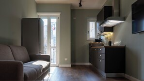 A compact kitchen with a built-in oven, a sink, and a window. - Eleganza Metropolitana (Turin)