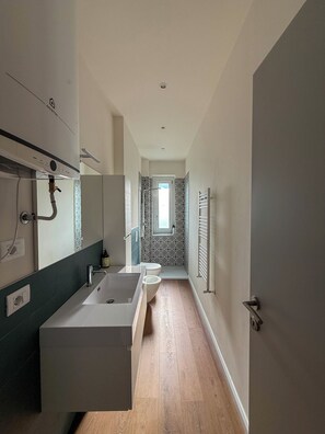 A modern bathroom with a large sink, toilet, and shower area. - Eleganza Metropolitana (Turin)