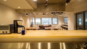Une cuisine moderne dotée d’appareils électroménagers en acier inoxydable, de plans de travail en bois et de luminaires suspendus.