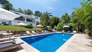 A swimming pool with lounge chairs and umbrellas, surrounded by a stone patio and greenery. - Villa Anna on the Côte d'Azur | 8 bedrooms, private Padel and P (Valbonne)