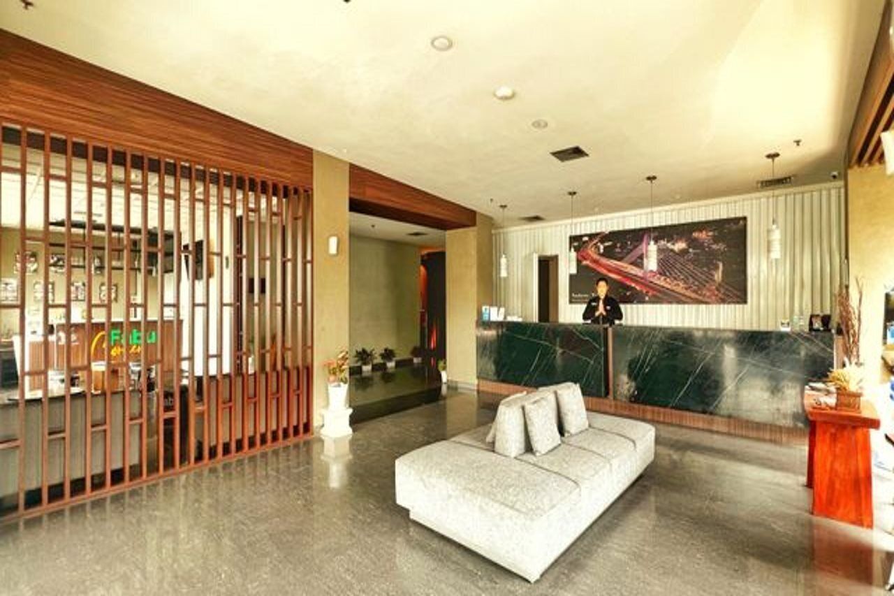 A modern lobby with a reception desk, a sofa, and a large cityscape mural.