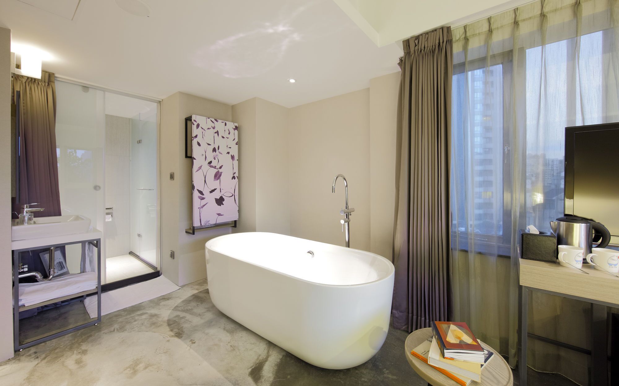 A modern bathroom with a freestanding bathtub, a glass shower enclosure, and a vanity with a mirror.