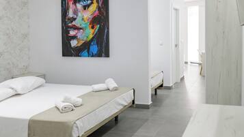 A hotel room with two beds, a large abstract painting on the wall, and a view of the hallway.