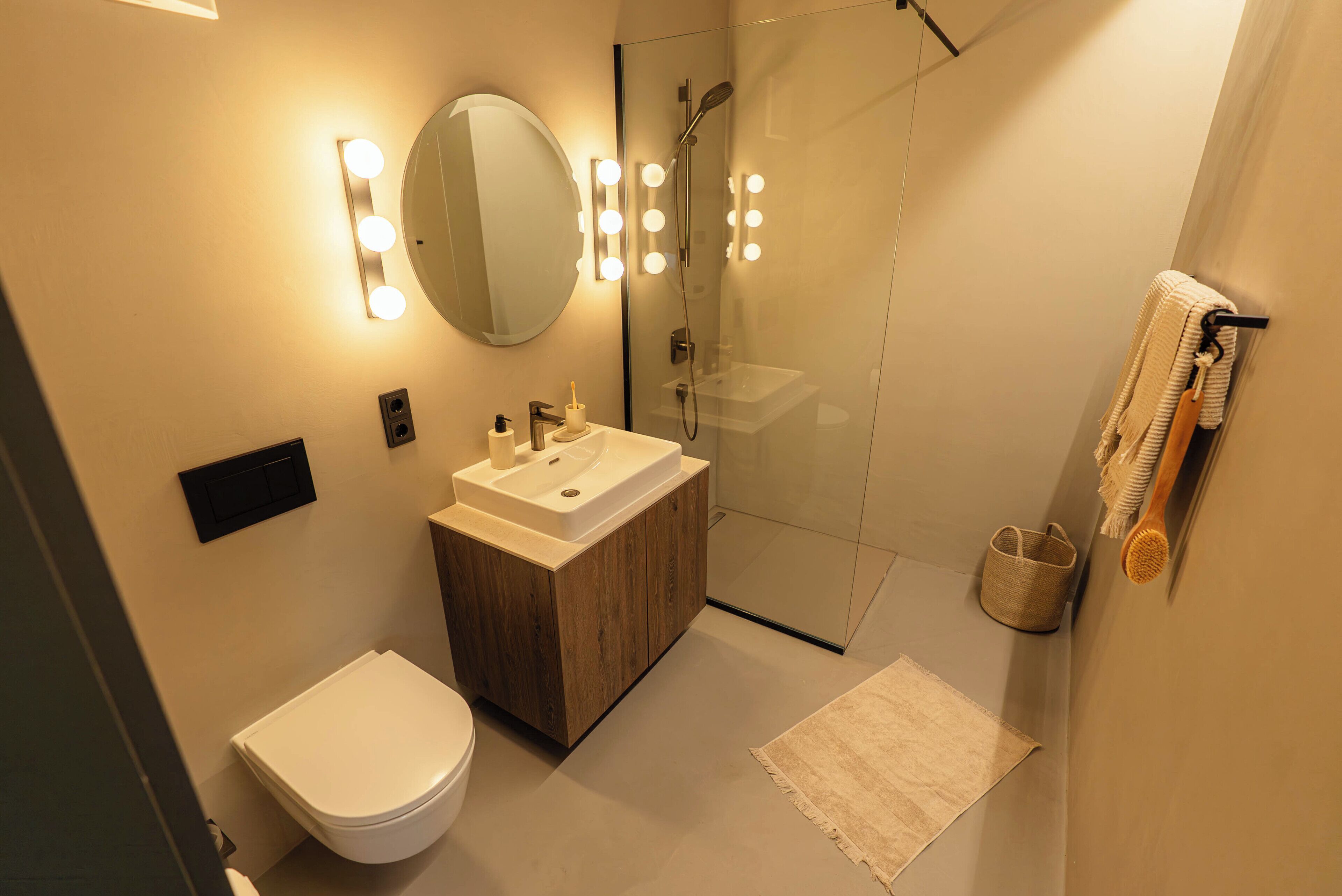 A modern bathroom with a toilet, sink, and shower.