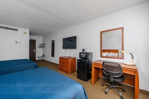 A hotel room with two beds, a desk with a chair, a television, a mirror, and a microwave. - Dakotah Lodge (Sioux Falls)