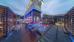 A modern building with a rooftop patio area featuring outdoor seating and a water feature. - Yeon Hwa Moon Hotel (Incheon)