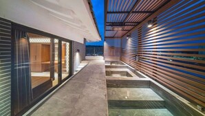 A modern outdoor corridor with a tiled floor, wooden slatted walls, and a glass door on the left. - Yeon Hwa Moon Hotel (Incheon)