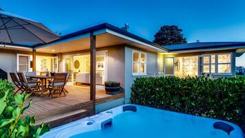 Una casa moderna con patio, jacuzzi e interior bien iluminado.