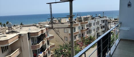 A residential building with multiple balconies overlooking a coastal area.