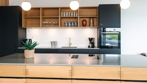 Una cucina moderna con mobili in legno, un'isola centrale e luci a sospensione.