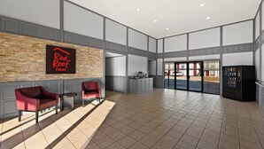 A spacious lobby with a Red Roof Inn sign, a reception desk, and a vending machine. - Red Roof Inn Nacogdoches (Nacogdoches)