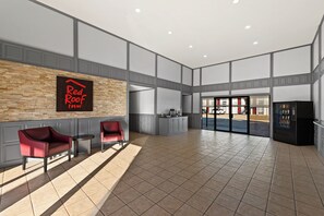 A spacious lobby with a Red Roof Inn sign, a reception desk, and a vending machine. - Red Roof Inn Nacogdoches (Nacogdoches)