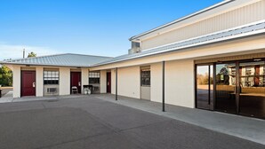 A building with a flat roof, large windows, and a covered entrance. - Red Roof Inn Nacogdoches (Nacogdoches)