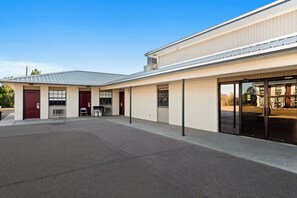 A building with a flat roof, large windows, and a covered entrance area. - Red Roof Inn Nacogdoches (Nacogdoches)