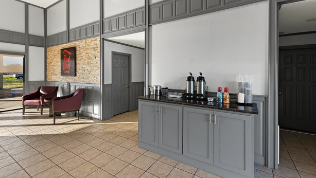 A modern kitchen with a granite countertop, a coffee machine, and a refrigerator. - Red Roof Inn Nacogdoches (Nacogdoches)