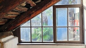 A room with a large window, wooden beams, and a view of the street outside. - Cavigliano Rustic (Cavigliano)