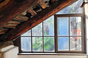 A room with a large window, wooden beams, and a view of the street outside. - Cavigliano Rustic (Cavigliano)