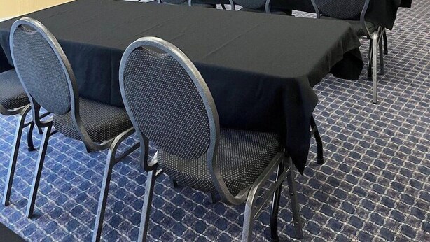 A conference room with a large table, six chairs, a projector screen, and two wall-mounted flower arrangements. - Quality Inn Carlisle (Carlisle)