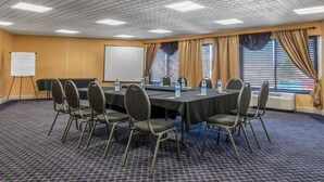 A conference room with a long table, chairs, a whiteboard, and windows with curtains. - Quality Inn Carlisle (Carlisle)