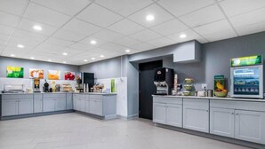 A modern kitchen with grey cabinets, a coffee machine, and a refrigerator. - Quality Inn Carlisle (Carlisle)