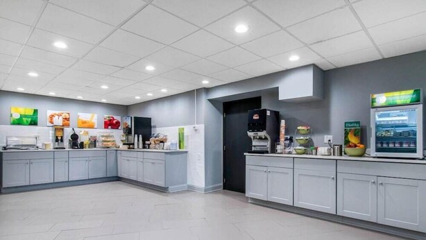A modern kitchen with grey cabinets, a coffee machine, and a refrigerator. - Quality Inn Carlisle (Carlisle)