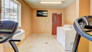 A laundry room with a treadmill, a washing machine, and a dryer. - Cobblestone Hotel Suites Punxsutawney Pa (Punxsutawney)