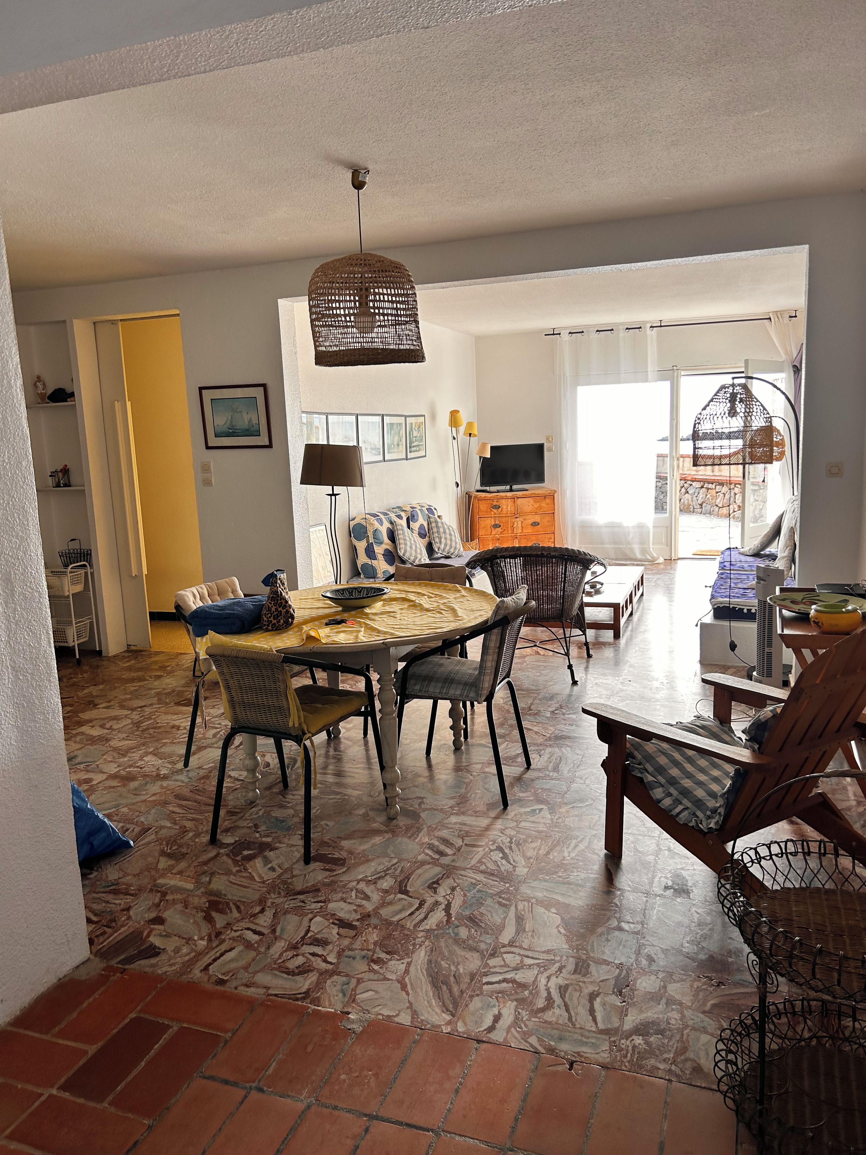 A dining area with a table, chairs, and a television.