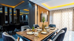 Un espace repas moderne avec une table en bois mise pour le repas, entourée de chaises.