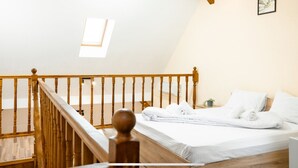 A bedroom with a wooden bed, white bedding, a skylight, and a wooden staircase. - 1st Nest in Heart of Timisoara (Timisoara)
